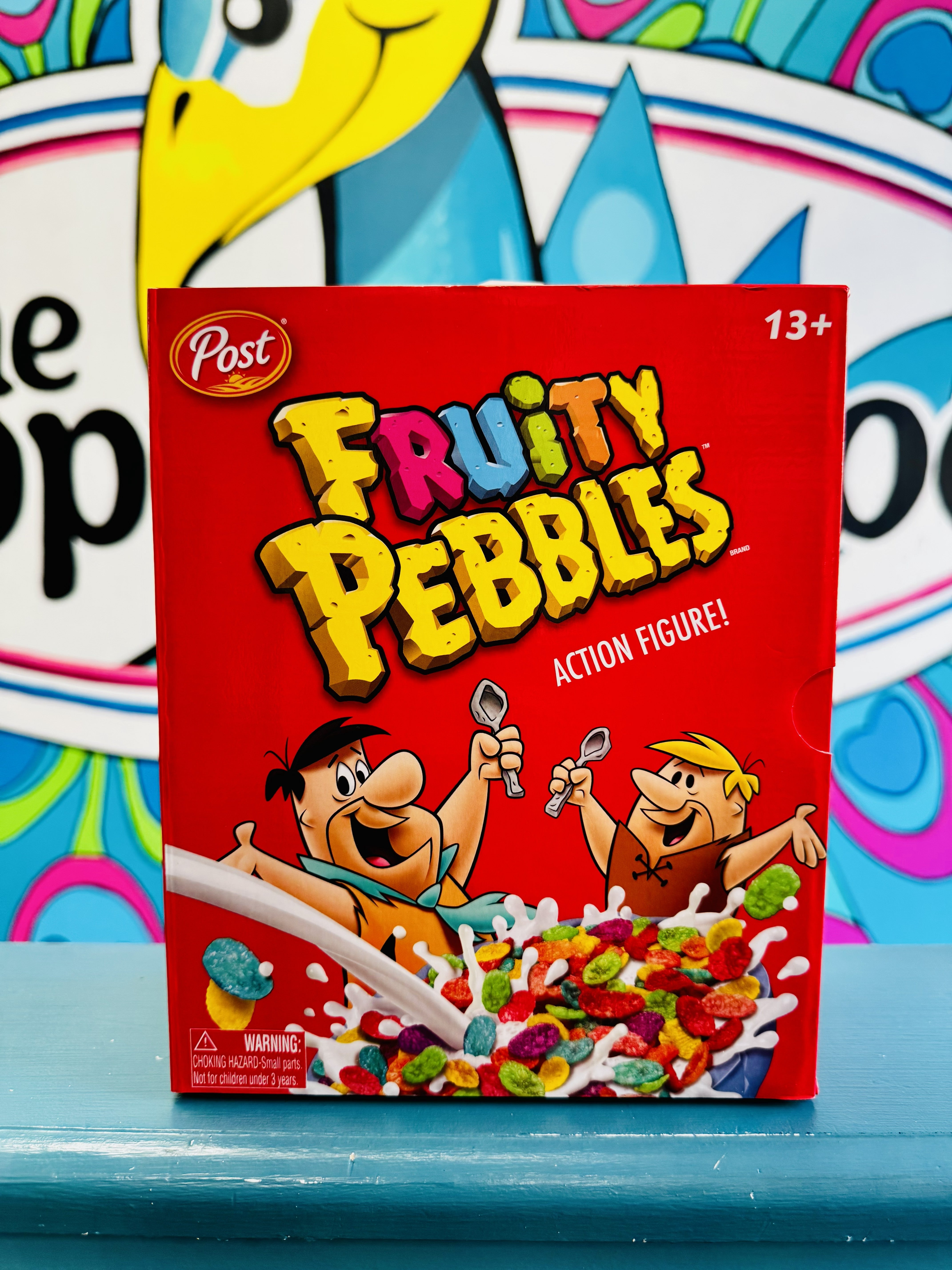 Fruity Pebbles Fred Flintstone action figure in red cereal box-style packaging