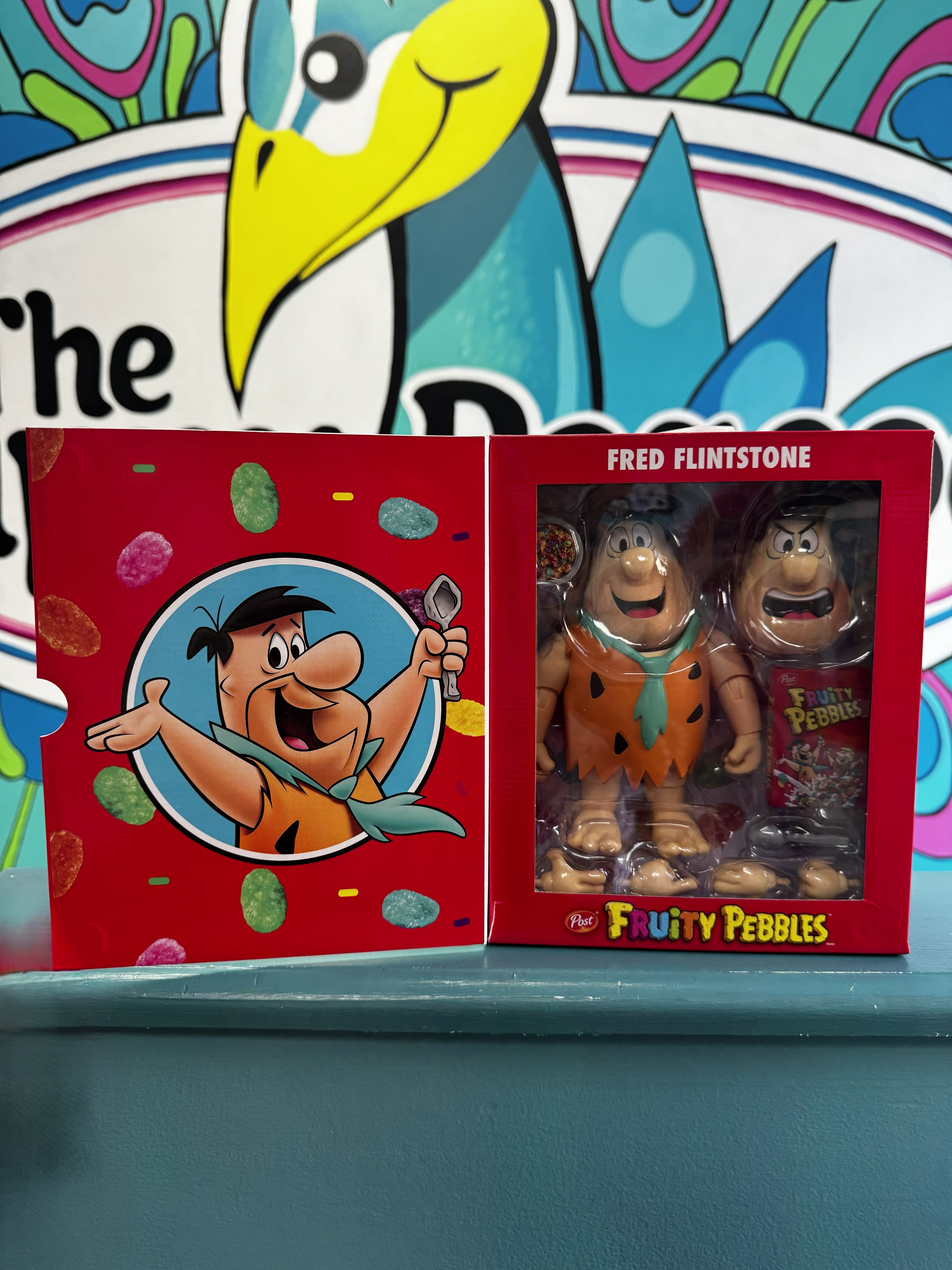 Fruity Pebbles Fred Flintstone action figure in red cereal box-style packaging