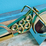 Gold motorcycle pizza cutter angled view on its teal stand