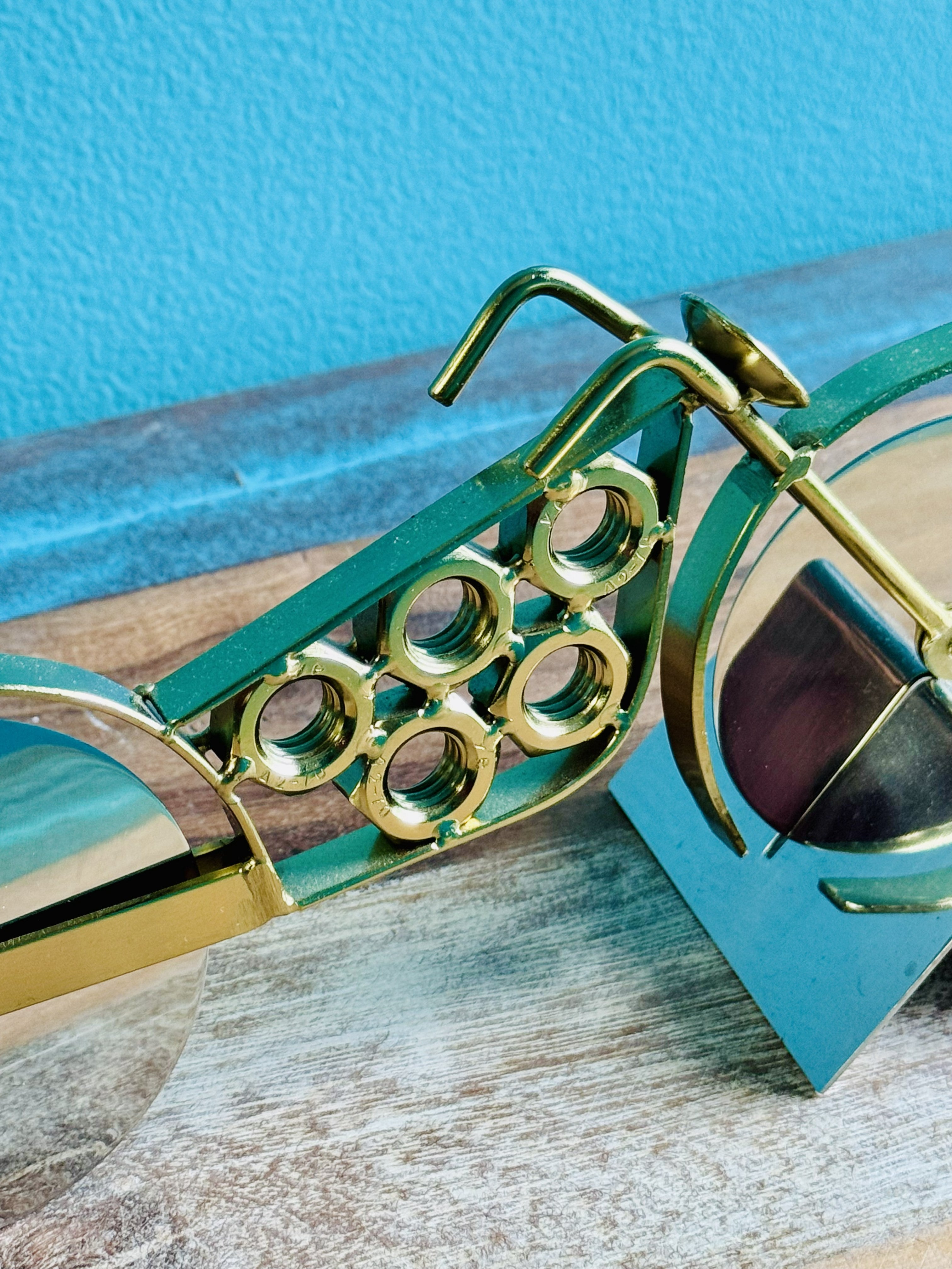 Gold motorcycle pizza cutter angled view on its teal stand